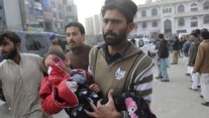 A man carrying an injured child. AP PHOTO