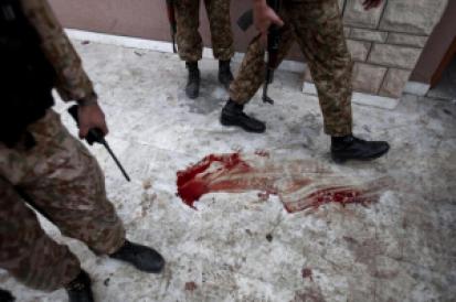 Pakistani troops walk over blood stained floor schools